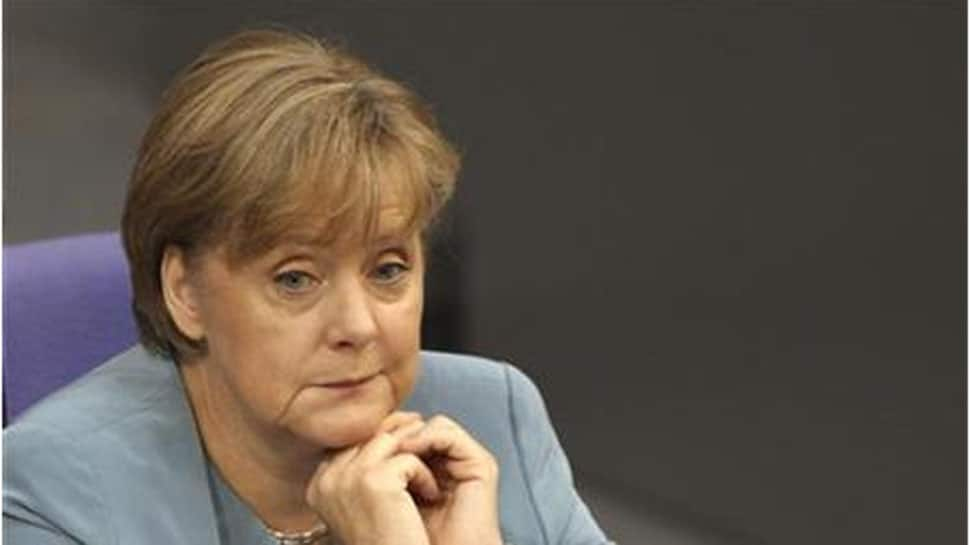 Merkel sits rather than stands at public ceremony, following shaking bouts