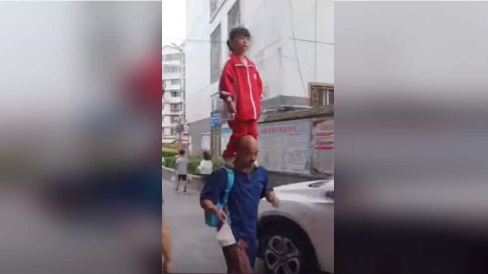 Watch: Chinese girl balances on grandfather&#039;s shoulders while on her way to school