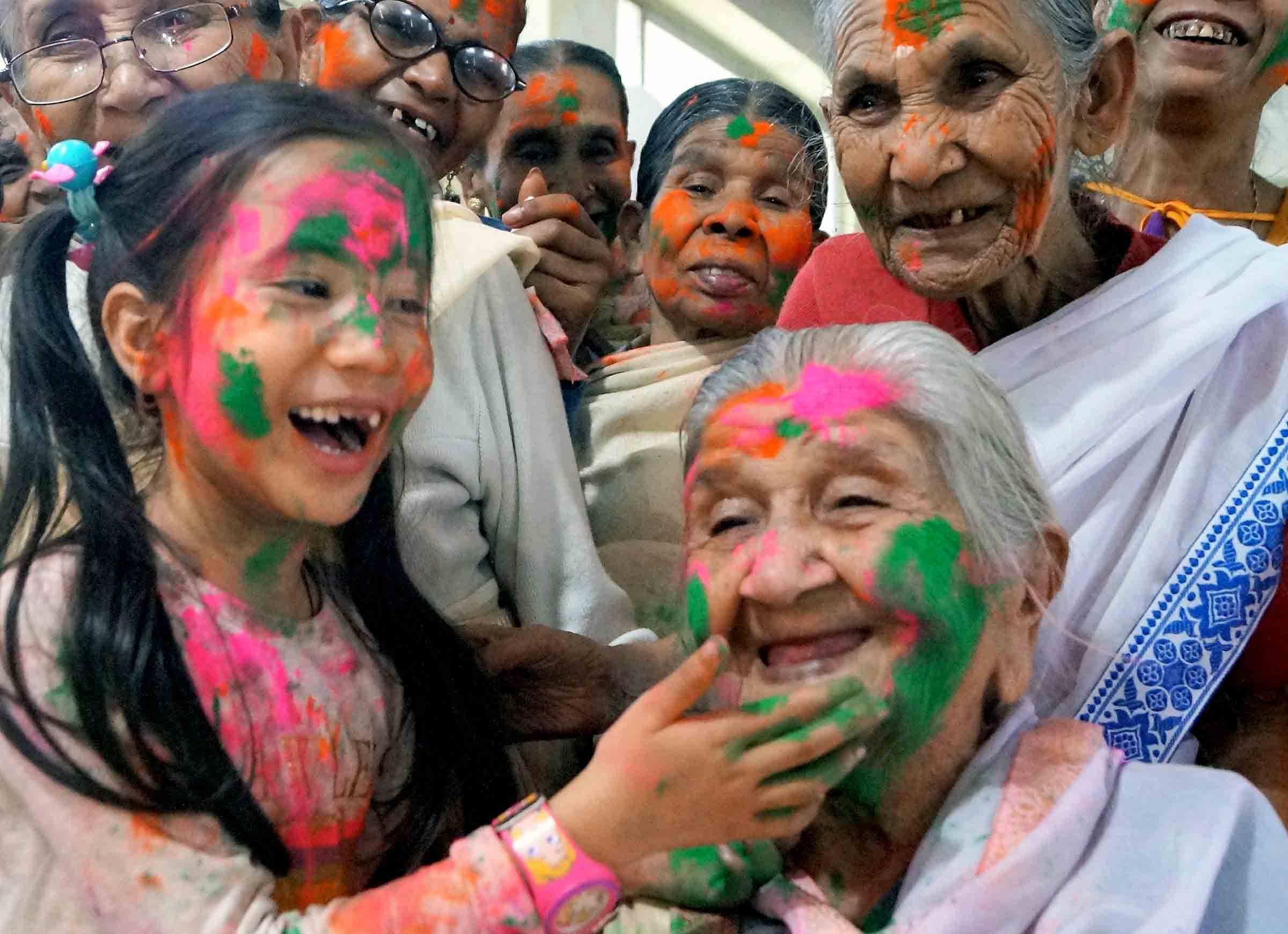 A little girl puts colours on an elderly women