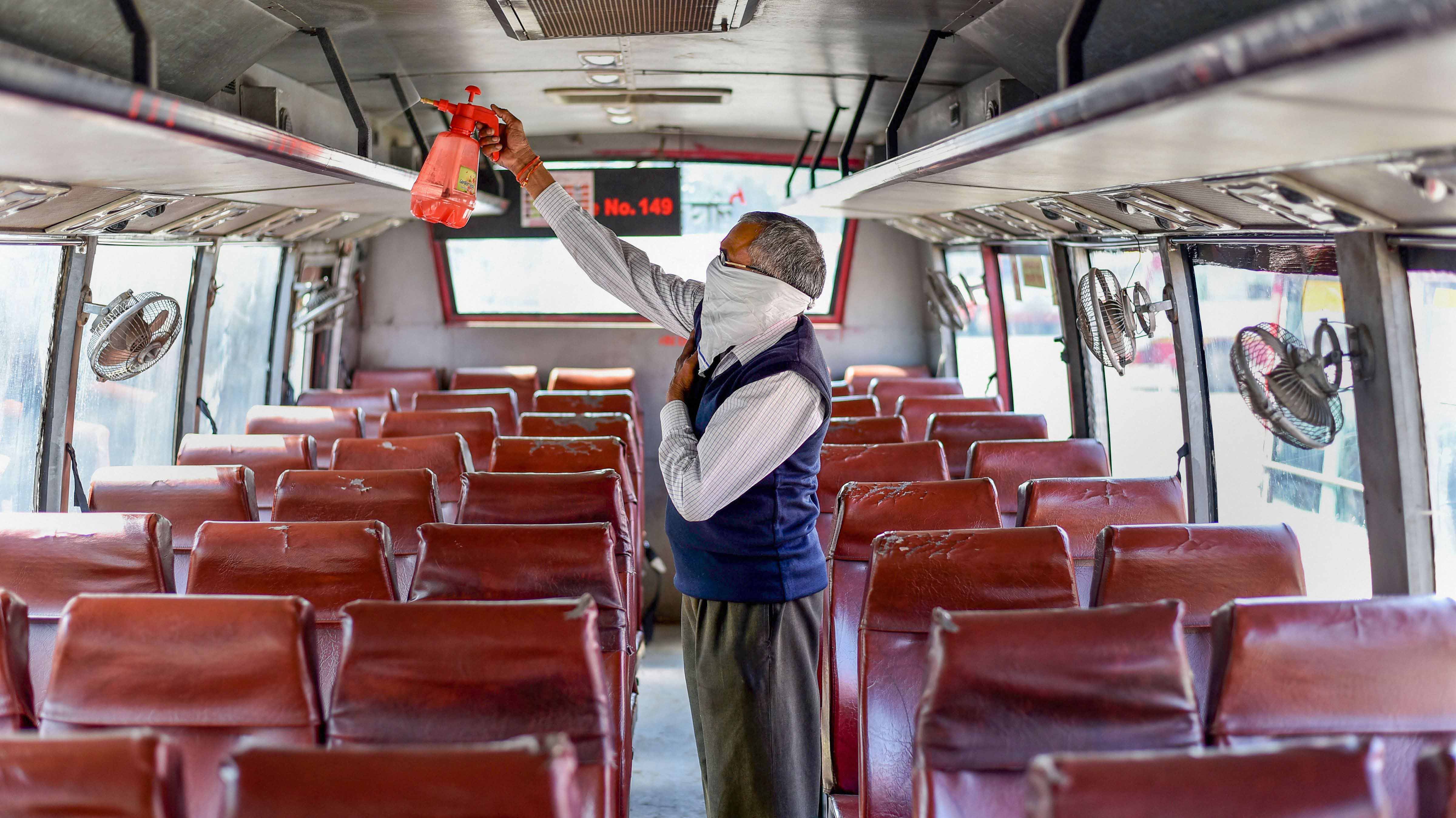 Worker carries out disinfection process of a bus