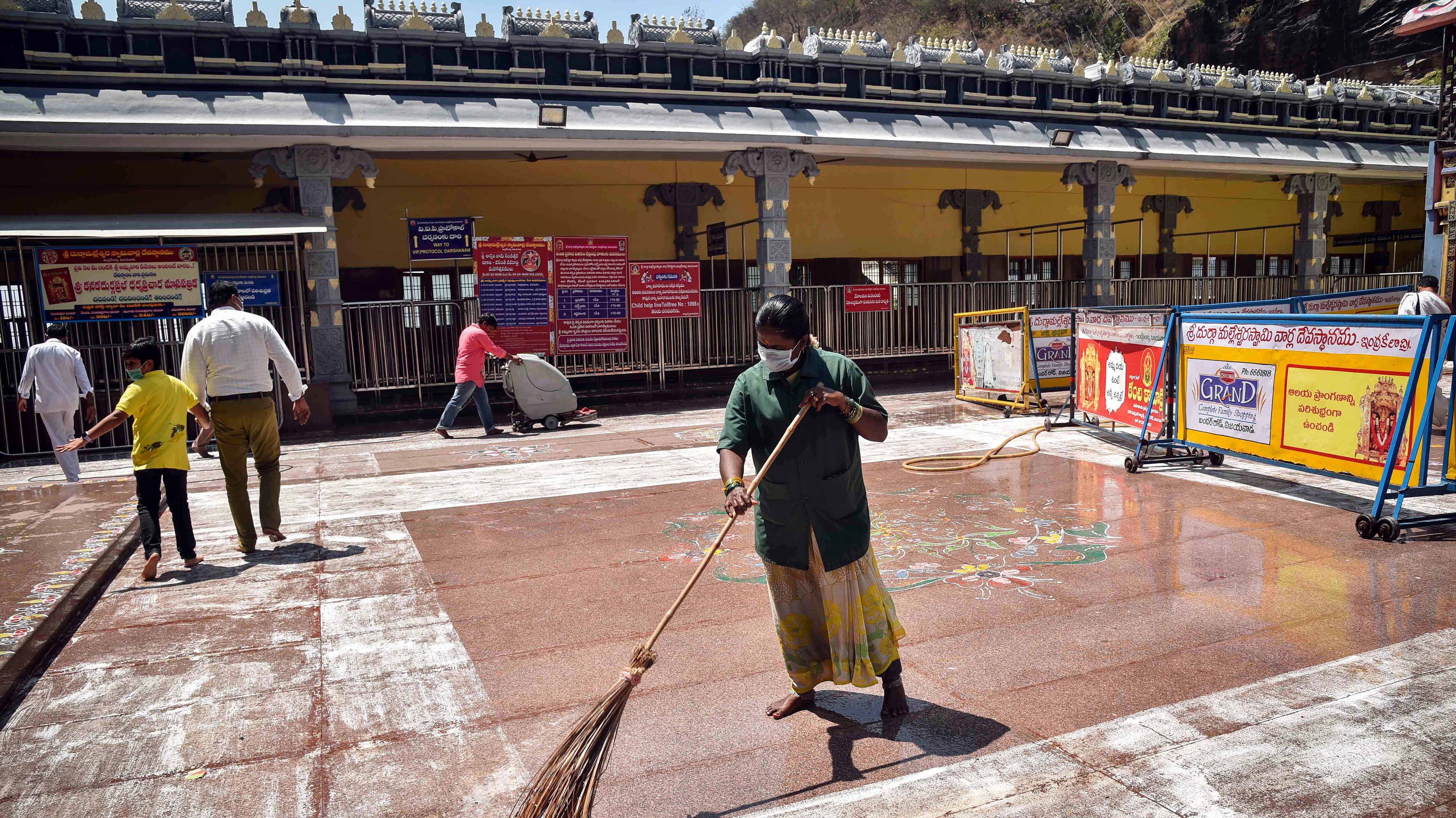 Workers clean the corridor of the Kanaka Durga temple 