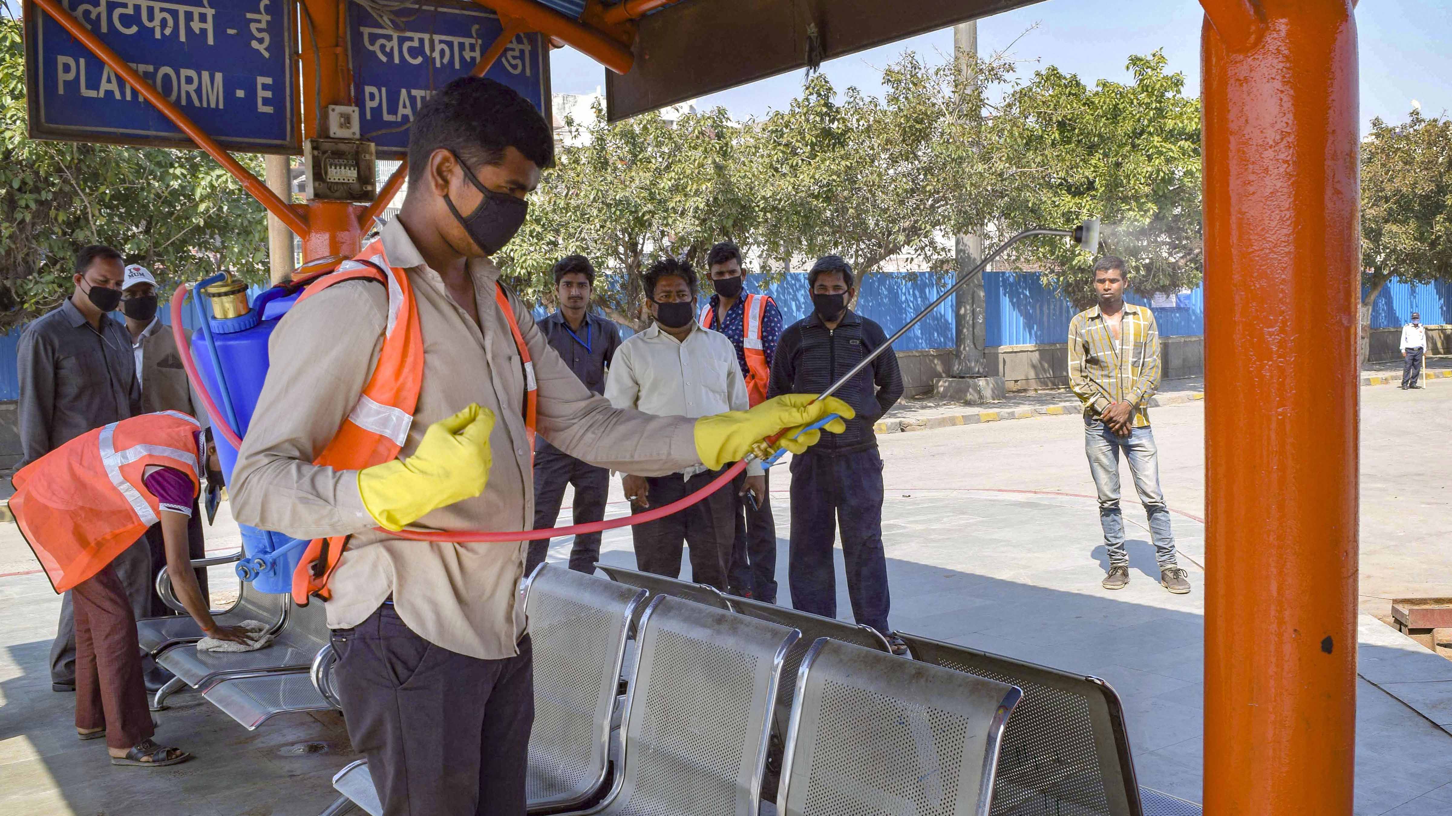 Volunteers spray disinfectant bus stand