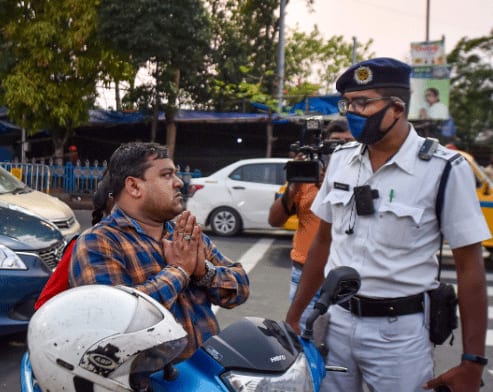 A police personnel stops a biker during lockdown in Kolkata