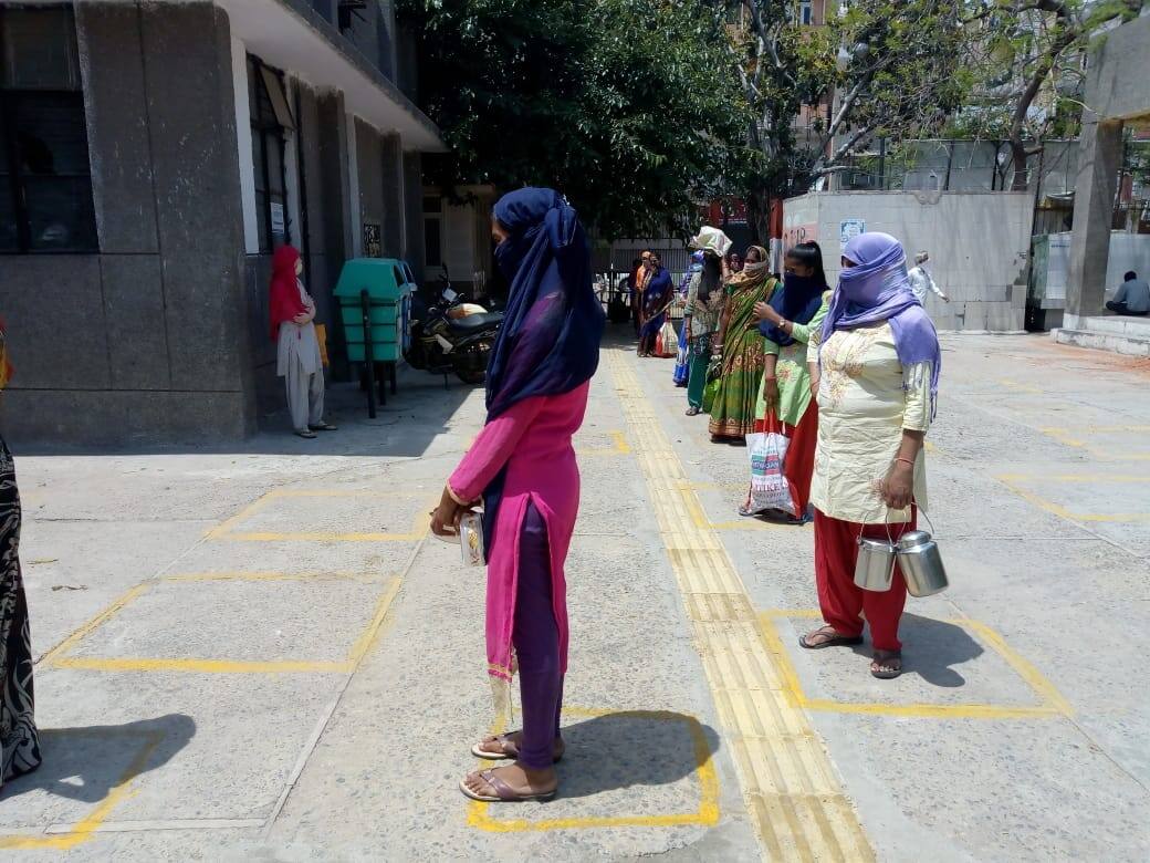 People practicing social distancing while collecting food 