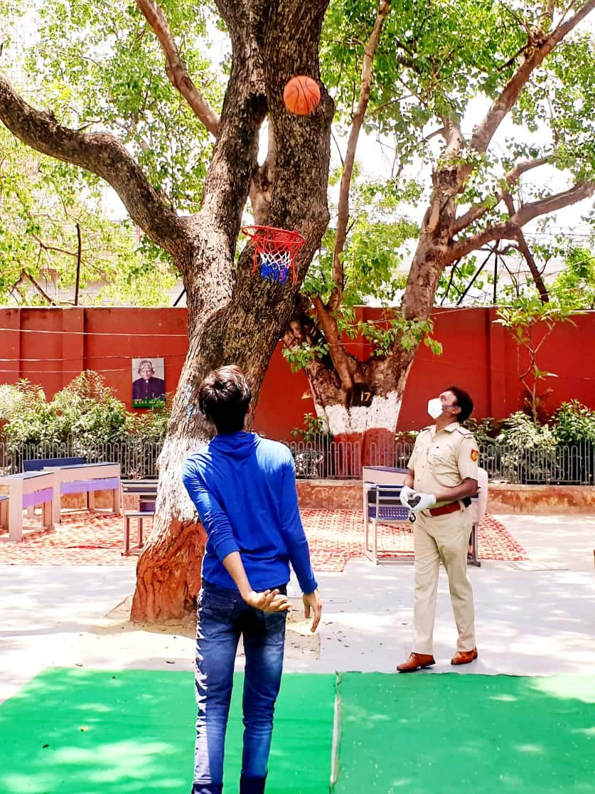 Delhi police constable plays with a boy in shelter home