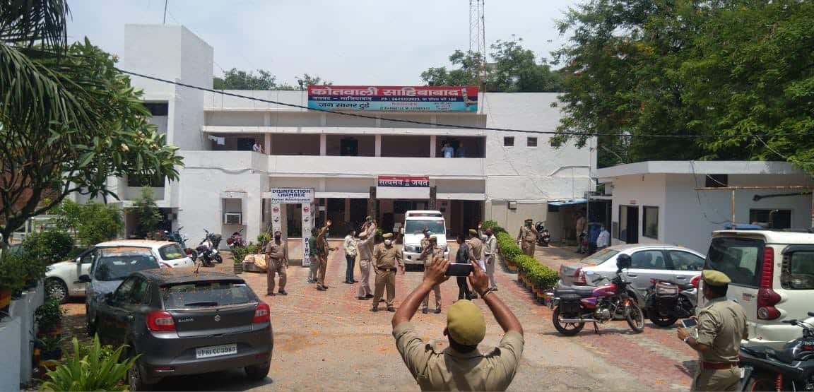 Police personnel taking pictures as IAF aircraft flypast Ghaziabad police station