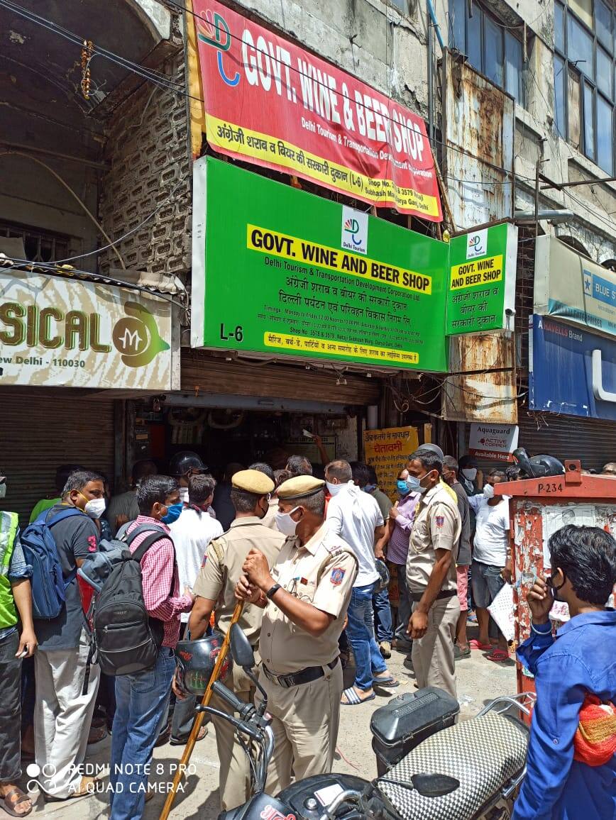 Police stand outside the liquor shop to check movement