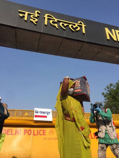 Woman with her luggage in front of New Delhi Railway Station