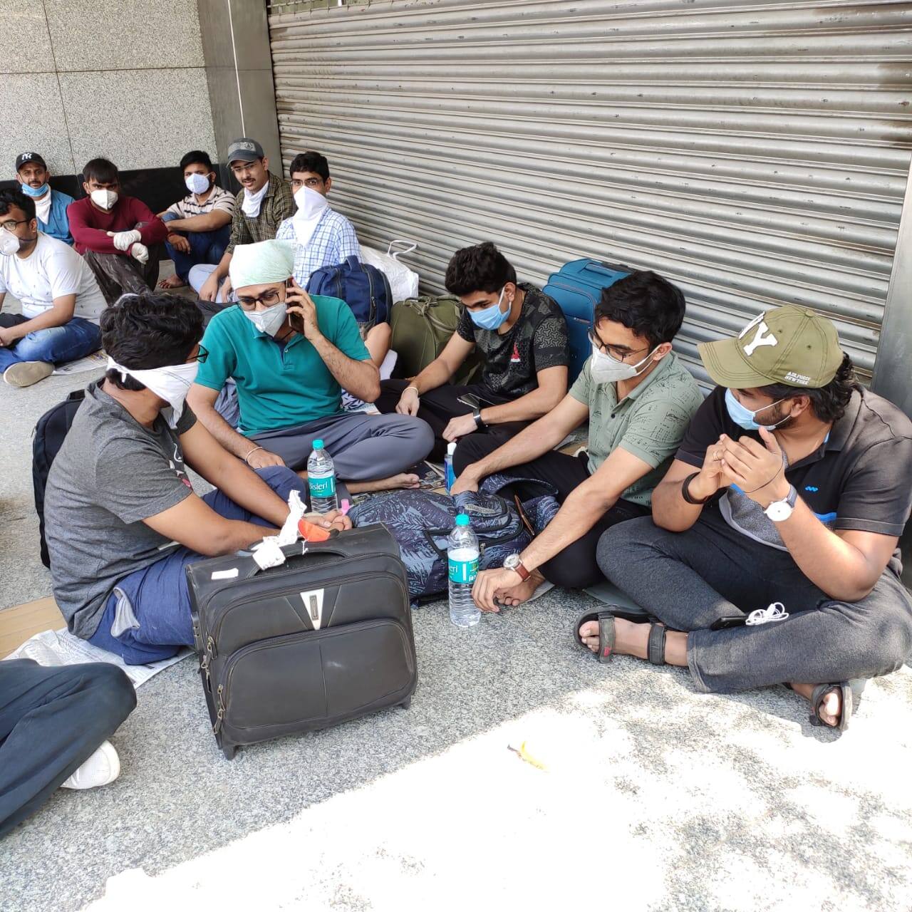 Students wait outside at Delhi's Ambedkar Stadium for screening before boarding train