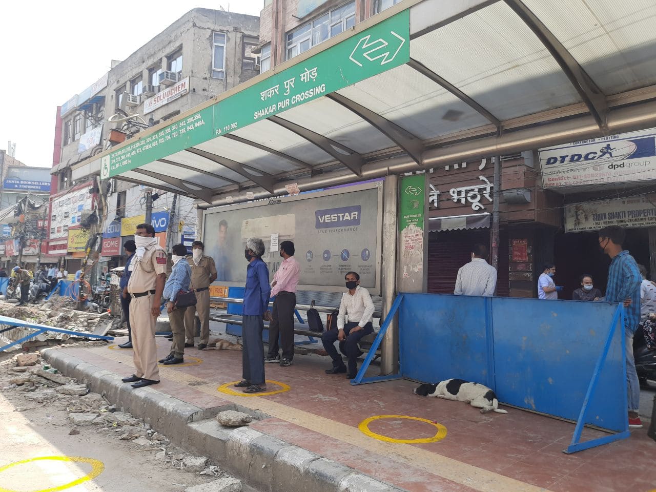 People follow social distancing at Shakarpur Mod bus stop in Delhi