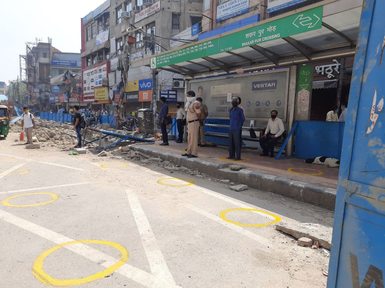 People follow social distancing at Shakarpur Mod bus stop in Delhi