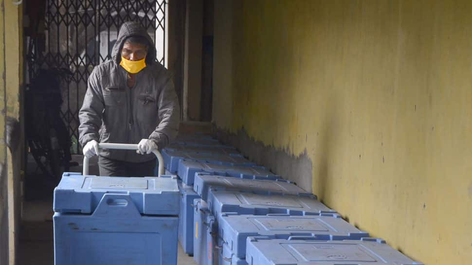 A worker arranges boxes containing Covishield vaccine doses