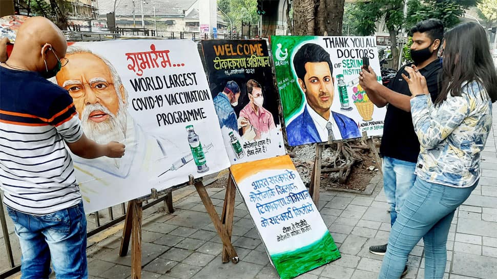 An artist of Gurukul School of Art paints a poster of vaccination drive