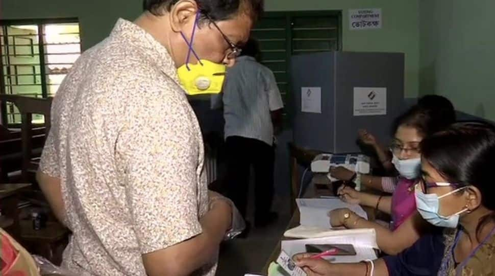 We can observe the voting underway at a polling centre in West Midnapore. The polling station workers are examining the voter's card.