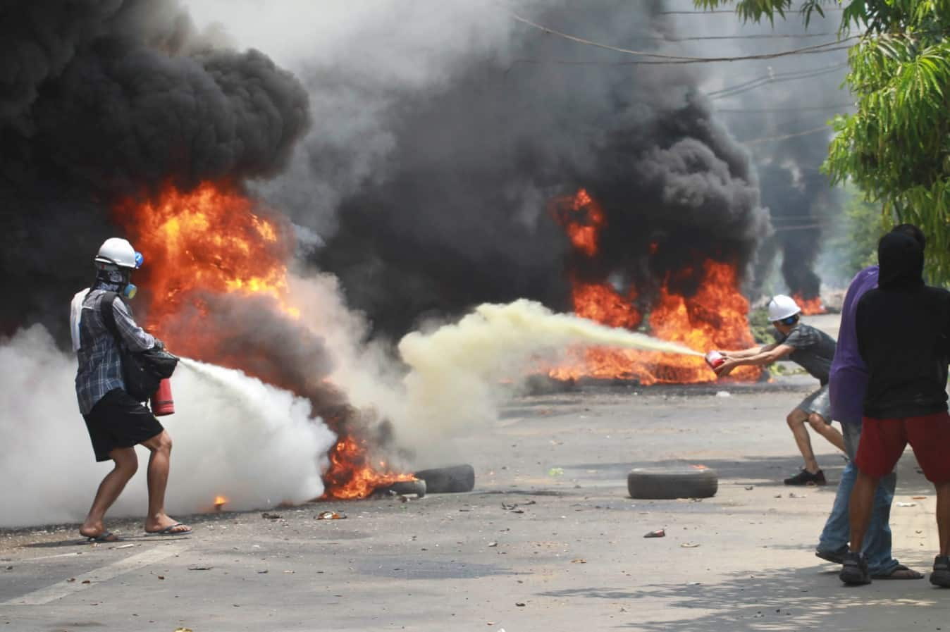 Anti-coup protesters extinguish fires during a protest