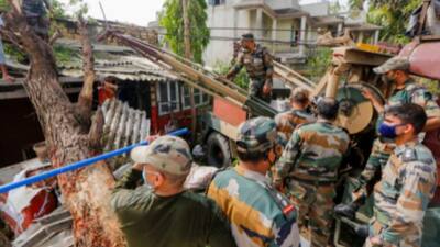 Army personnel remove uprooted tree in Diu