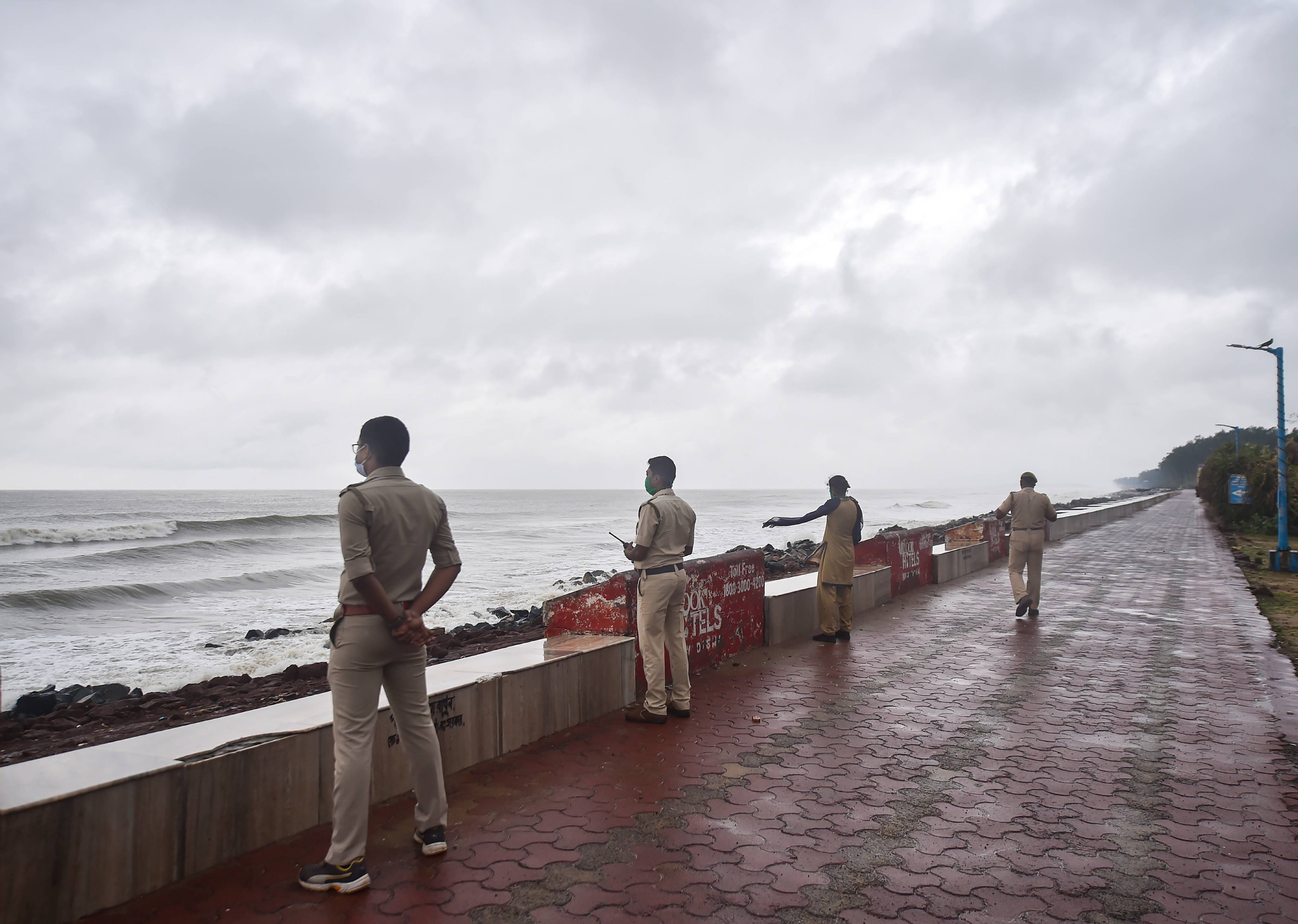 Police personnel patrol along a coastal area ahead of Cyclone 'Yaas'