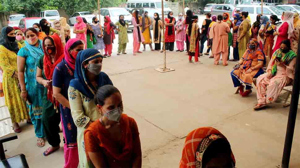 People stand in a queue to receive COVID19 dose