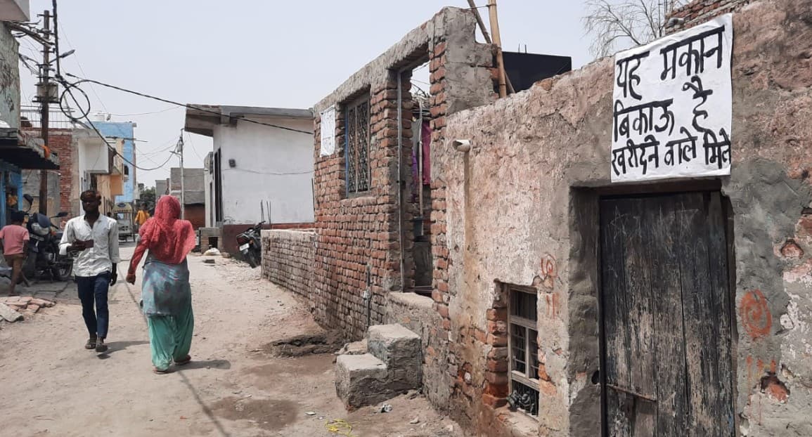 Posters reading 'House for sale' in a Hapur colony