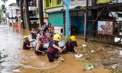 Municipal Corporation firefighters during a rescue operation after heavy rain in Kolhapur.