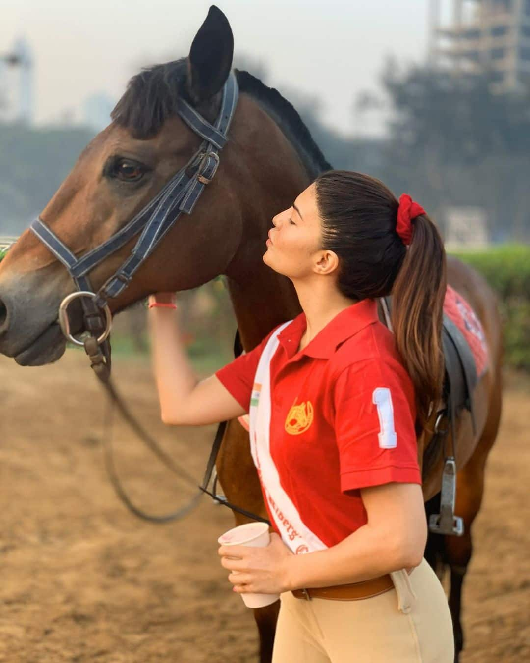 Jacqueline poses with a gorgeous brown horse