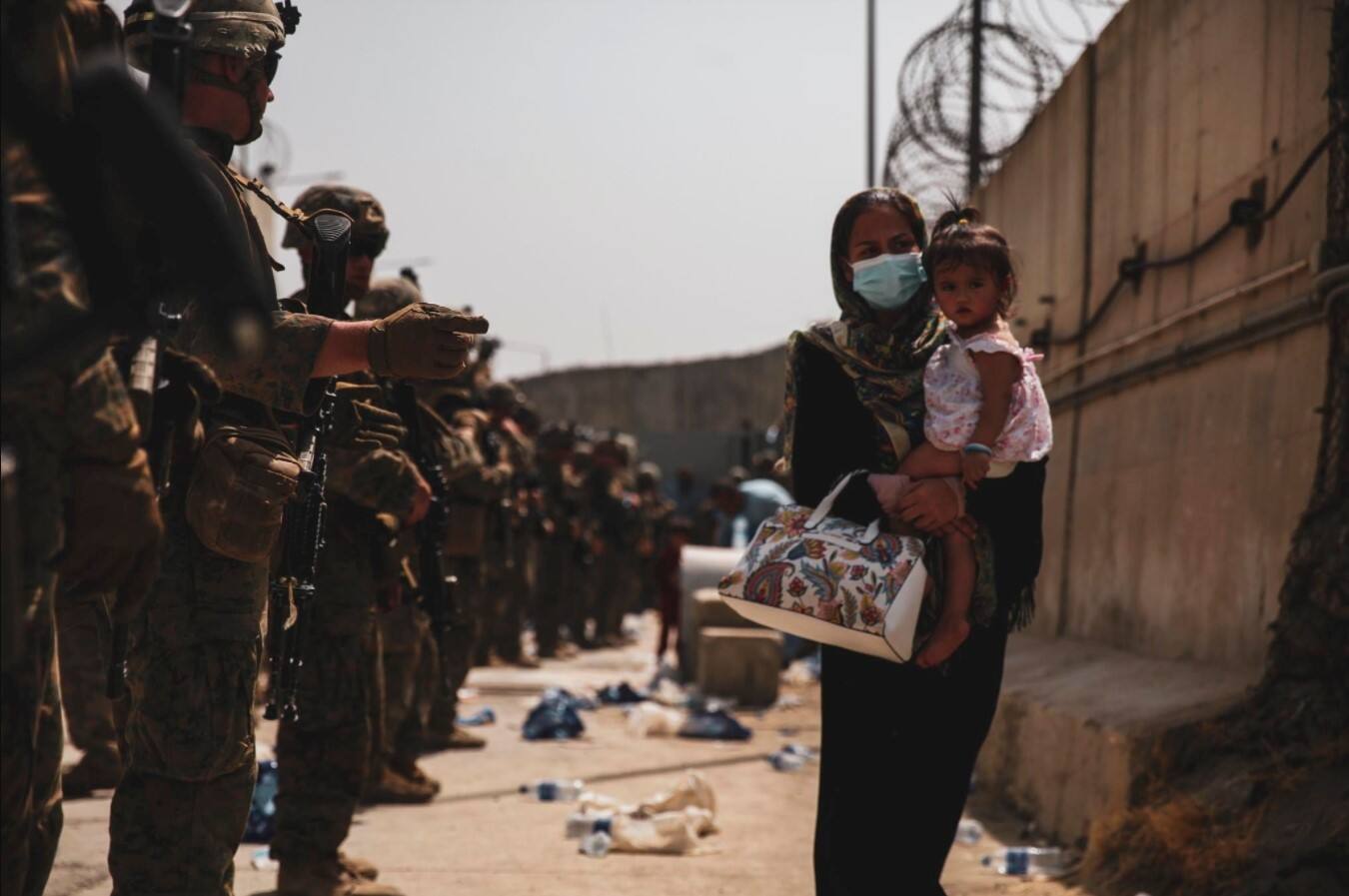 A woman walking with her child during evacuation at Hamid Karzai International Airport in Kabul