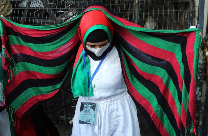 A woman wearing a shawl depicting the Afghan National flag takes part in a protest demanding the international community to help Afghan refugees, at the United Nations High Commissioner for Refugees (UNHCR), in New Delhi on Monday. 
