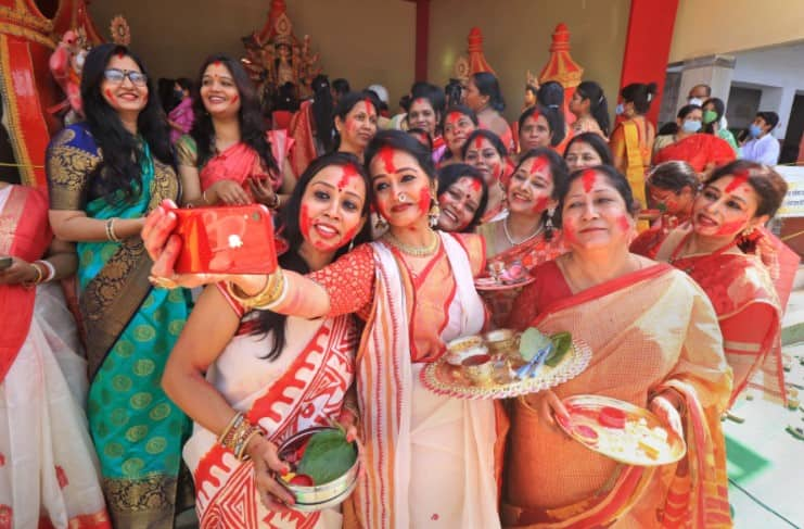 Women take selfies together on Durga Puja