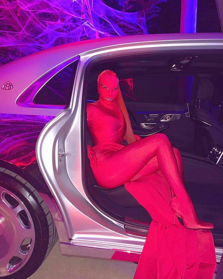 Kim Kardasian wears an all pink dress with full face mask and cut-outs for eyes and mouth