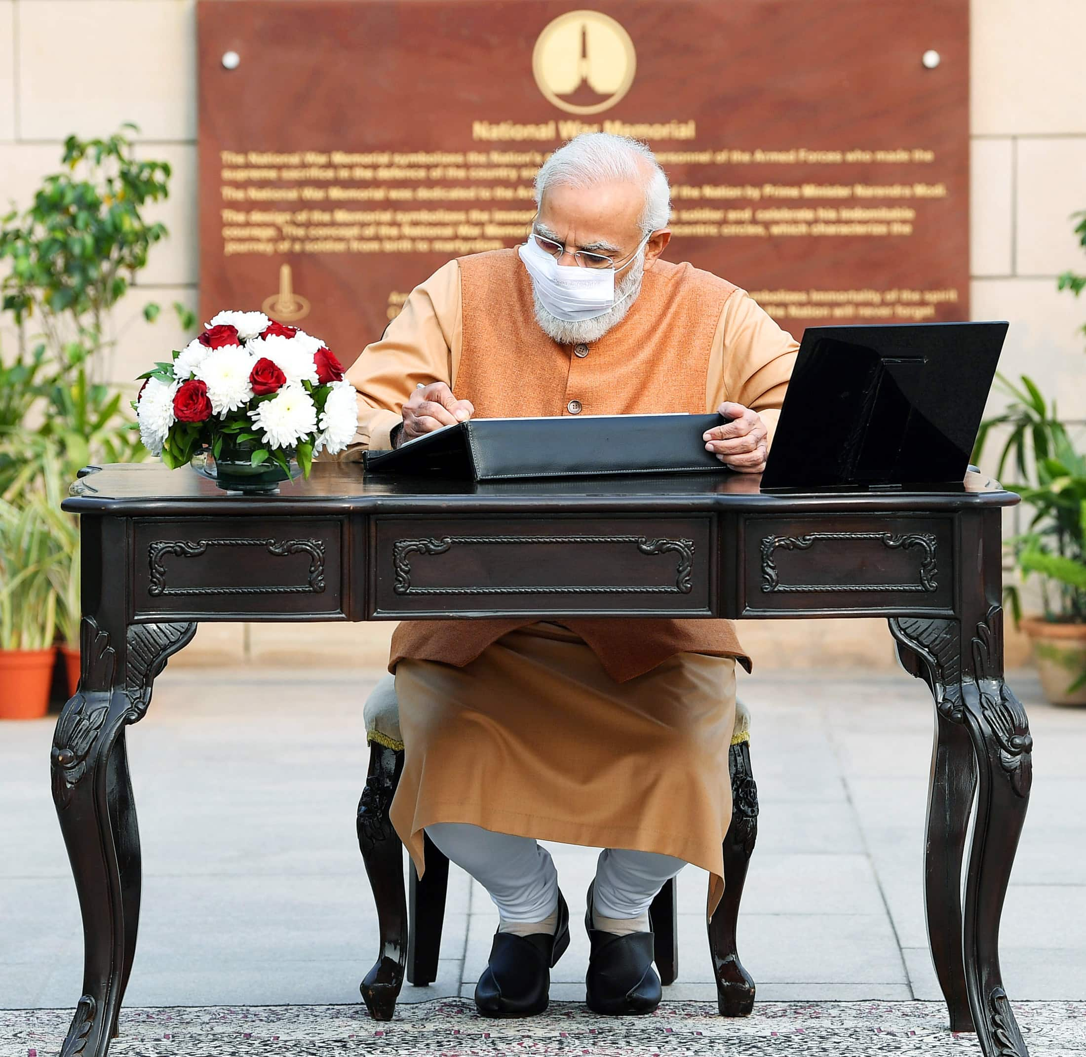 PM Modi signs visitors' book during Vijay Diwas ceremony.