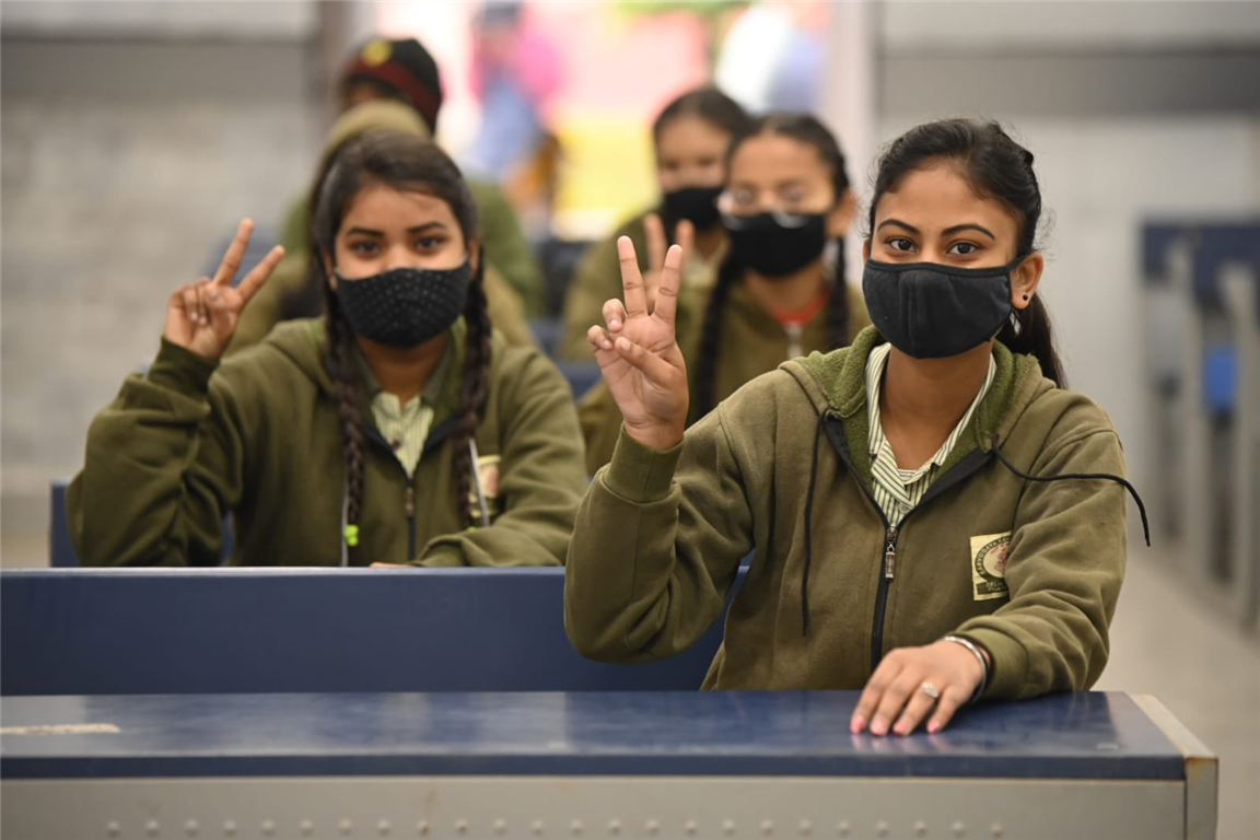 Students cheer as they attend a class in Delhi