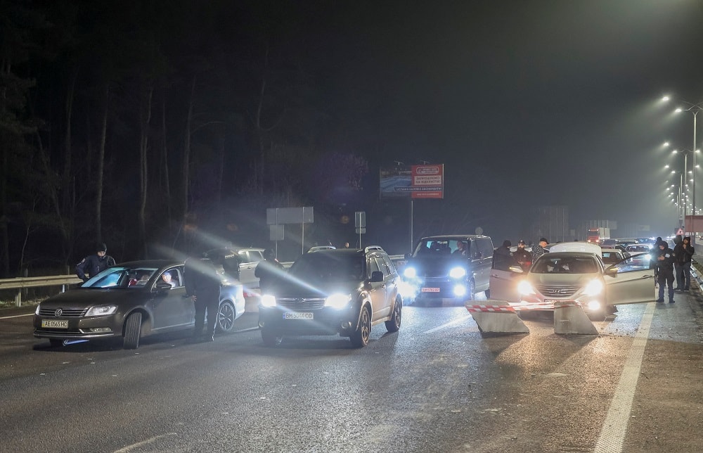 Police in Kyiv check cars on a road after Russia launched a military operation