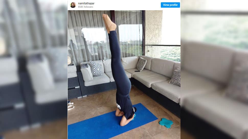 Practicing yoga in her home