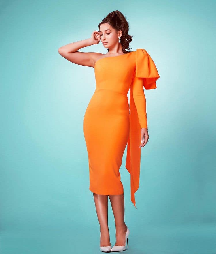 Nora wears bright one-shoulder orange dress