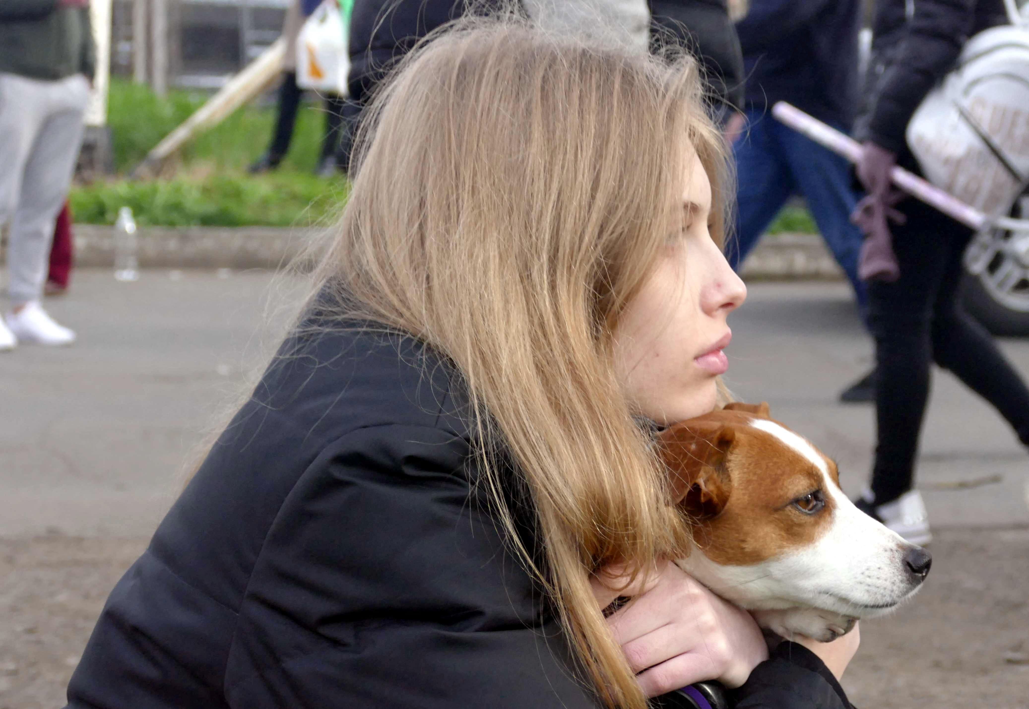 Ukrainian woman hugs her pet dog during the war