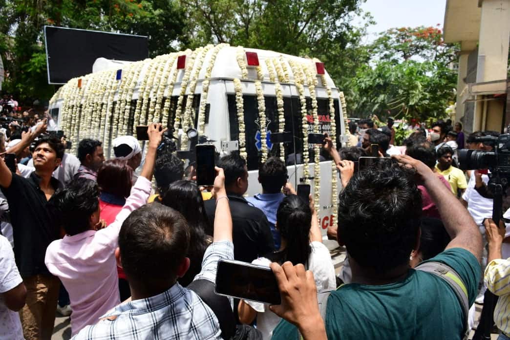 Ambulance adorned with flowers carrying KK's body