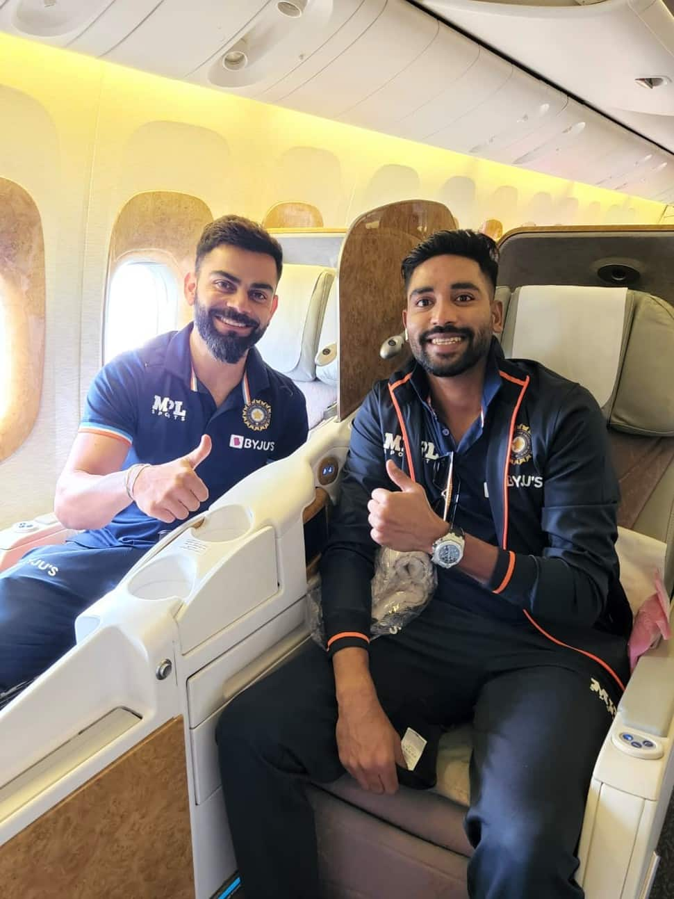 Former India captain Virat Kohli (left) with Mohammed Siraj on the Emirate flight to UK. (Source: Twitter)