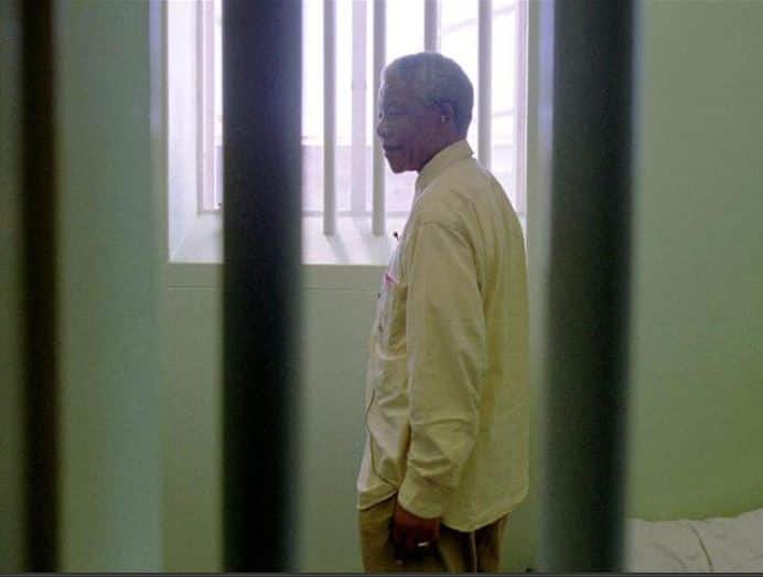 Nelson Mandela stares out of the window of the prison cell