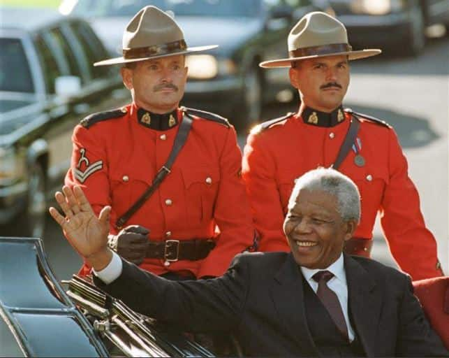 Nelson Mandela waves from a landau as he arrives at Rideau Hall