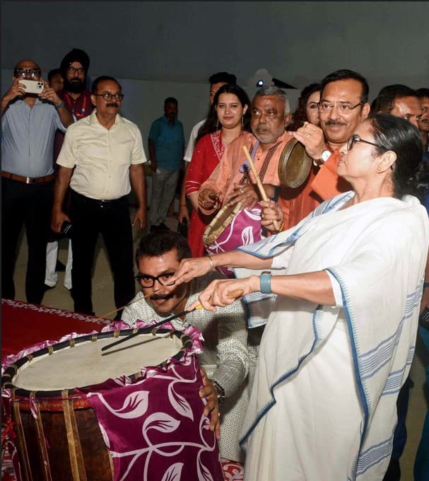 Mamata Banerjee playing 'dhaank' during festival