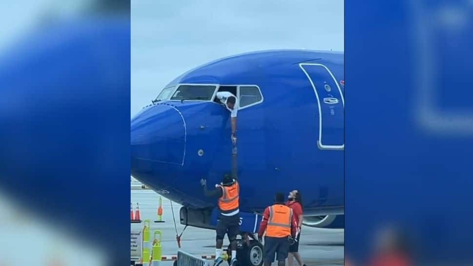 Pilot hangs from aircraft to retrieve passenger&#039;s lost phone, netizens applaud: WATCH Viral Video