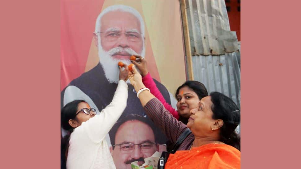 BJP Women workers offers sweets to PM Modi's poster