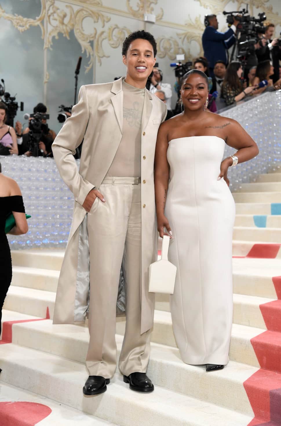 Brittney Griner became the first WNBA player to attend the Met Gala, months after being freed from Russian penal colony. She wore a tan ensemble from Calvin Klein that included tailored trousers and a long overcoat that felt cool and confident. Brittney's wife Cherelle wore a white strapless gown, also by Calvin Klein. (Photo: AP)