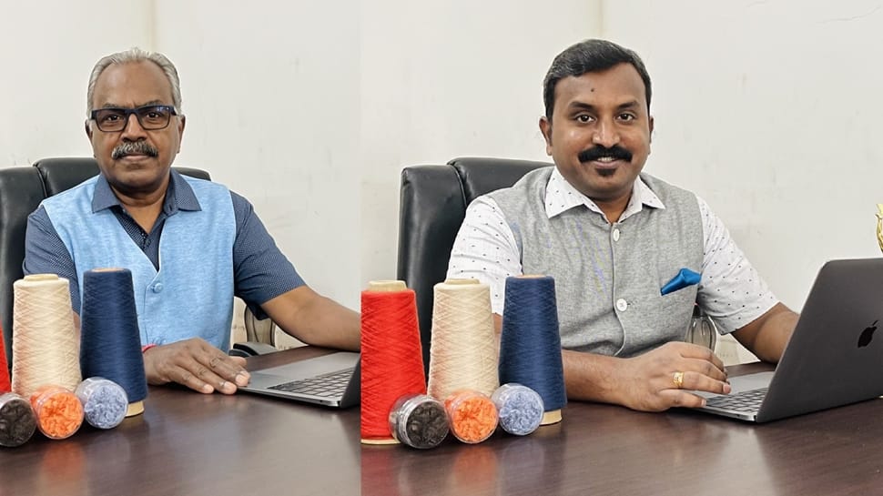 Father and son (6-8) recycling plastic bottles, smiling Stock