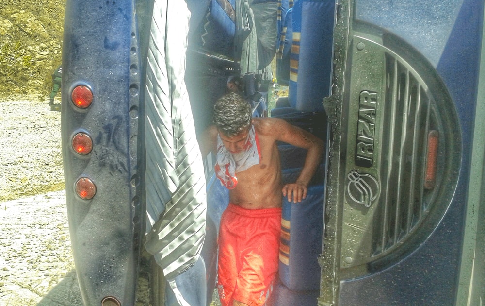 A young man emerges from the wreck of the bus that was transporting Agentina's Huracan soccer team to the airport, after it lost its brakes, lost control and flipped over, in Caracas.