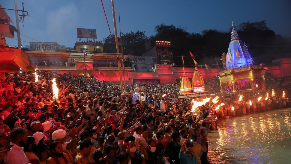 Devotees gather for an evening prayer on the banks of Ganges river during Kumbh Mela, or the Pitcher Festival, amidst the spread of the COVID-19