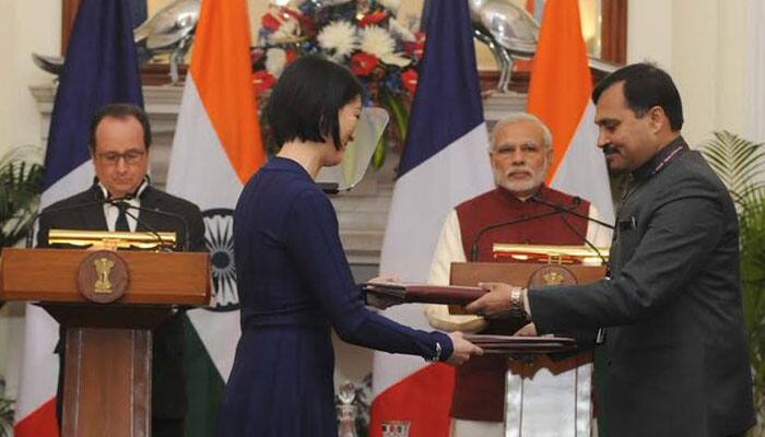 Delegates from both the sides exchange agreements at Hyderabad House. PM Modi and President Hollande in the background. Photo: Twitter/PIB