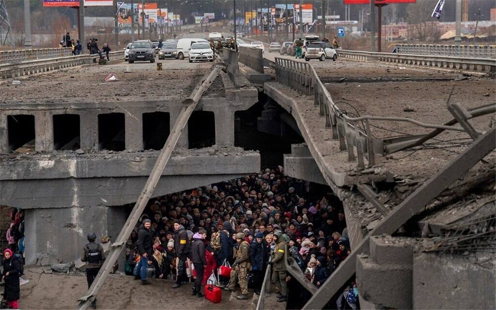 Civilians hide inside a broken bridge as evacuation continues