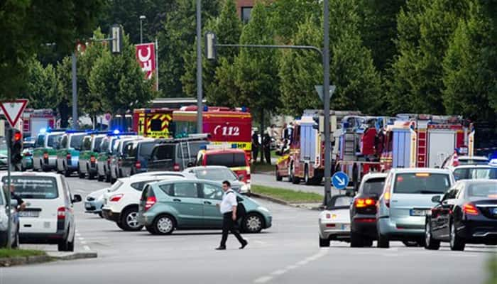 Police cars and fire trucks stand near a shopping centre in which a shooting was reported in Munich.