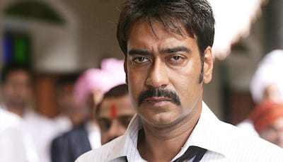 Who's name is Ajay Devgn getting tattooed?